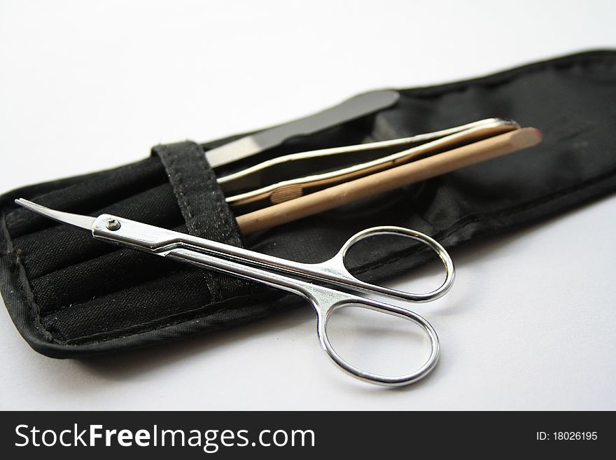 A black pouch containing scissors, nail file and tweezors. A black pouch containing scissors, nail file and tweezors