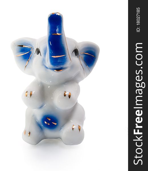 Porcelain cheerful elephant with raised trunk. Studio. Porcelain cheerful elephant with raised trunk. Studio.