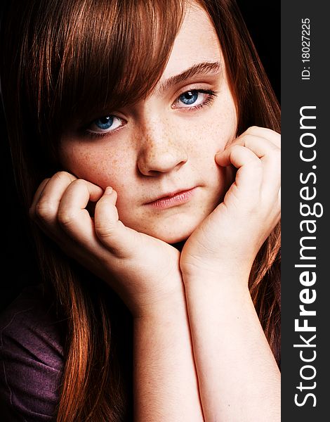 A beautiful young girl looking at the camera on a black background. A beautiful young girl looking at the camera on a black background.