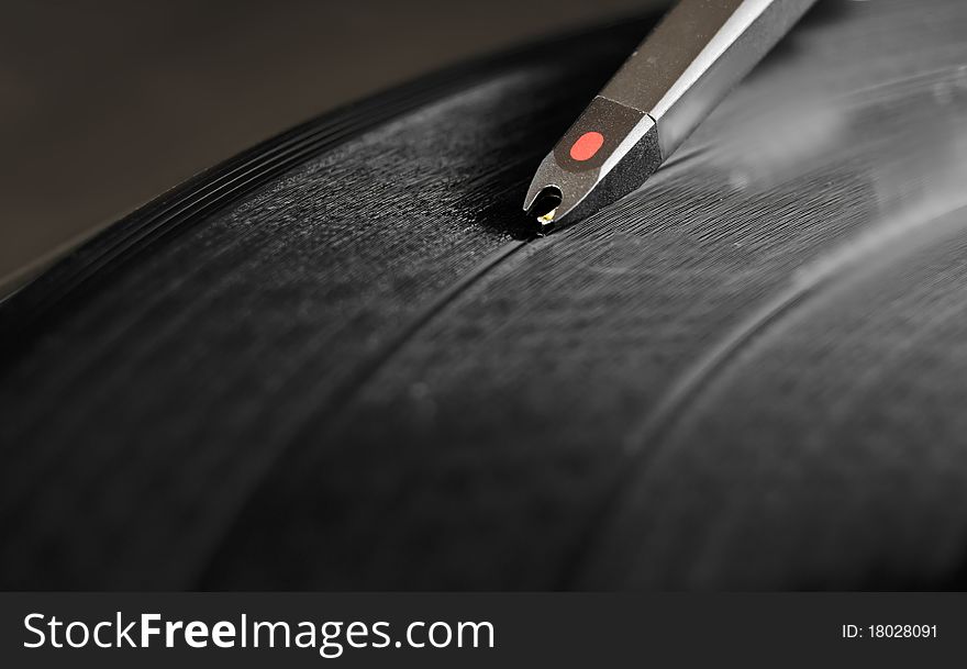 DJ record turntable. Macro closeup of the needle on a 12 inch vinyl LP playing hiphop techno rave beats.