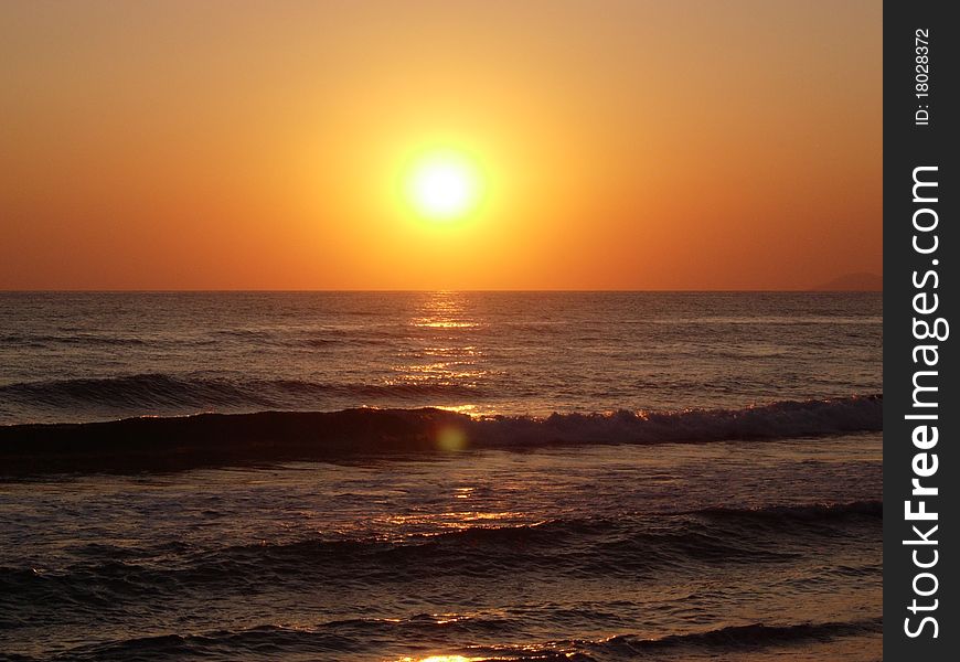 The sun falls over horizon sea line. The sun falls over horizon sea line