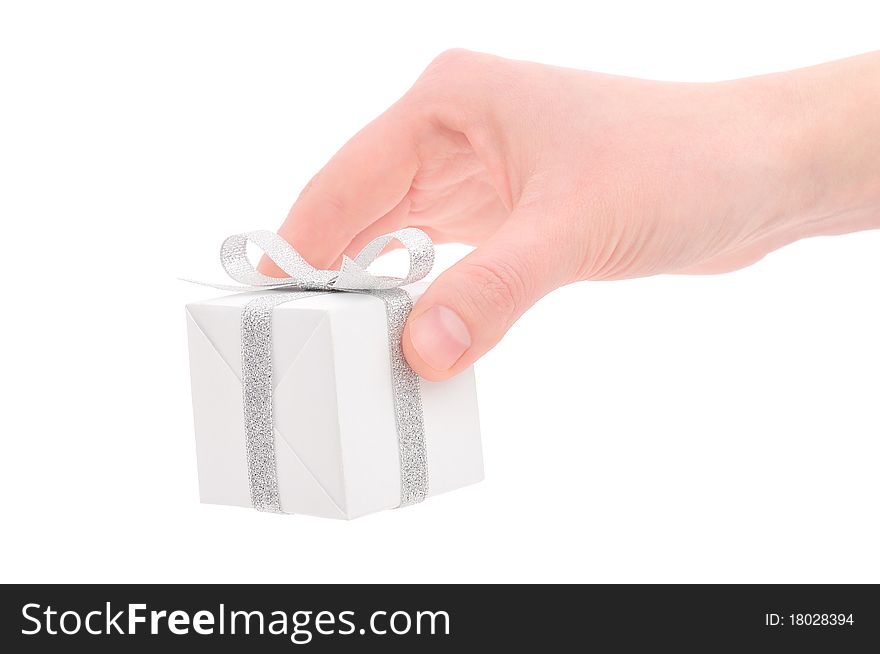 Woman's hand with a small white gift box with silver ribbon isolated on white background. Woman's hand with a small white gift box with silver ribbon isolated on white background.