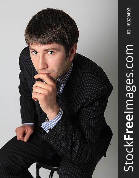 Man In Business Suit Sitting On A Chair