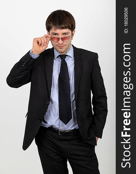 A business man in a suit adjusts glasses. A business man in a suit adjusts glasses