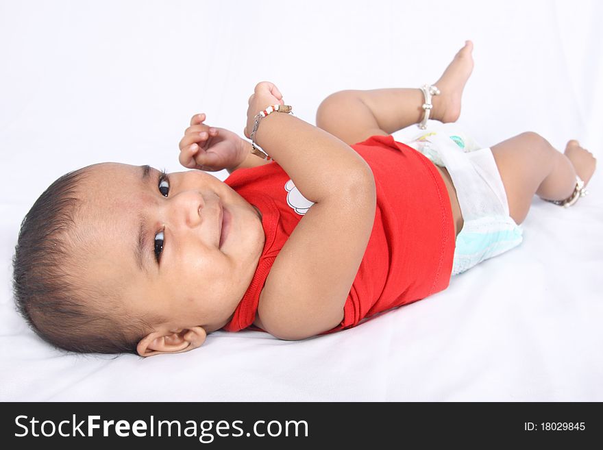 Smiling Indian Cute Baby lying on Bed