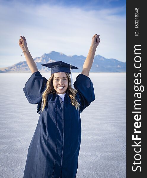 Cute Young Woman In Her Graduation Cap And Gown Showing Excitement After Graduating