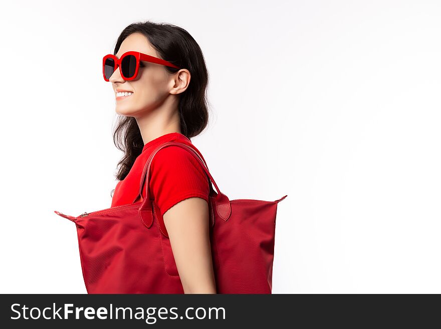 Fashionable woman hold shopper bag, wear retro sunglasses with happy face. Attractive beautiful young lady going to shopping in summer season. It shopping time isolated on white background, copy space