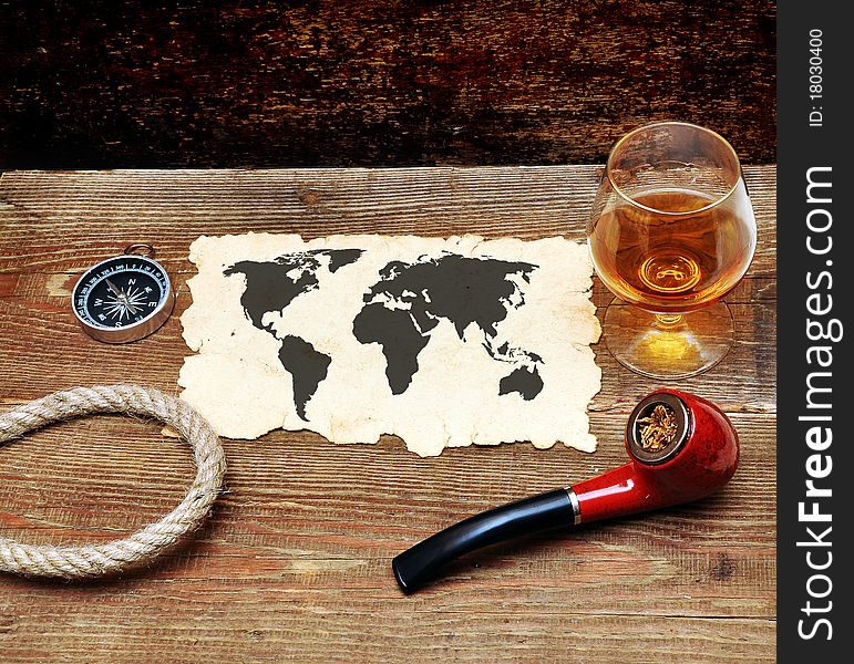 Old paper, pipe and glass of cognac on wood background