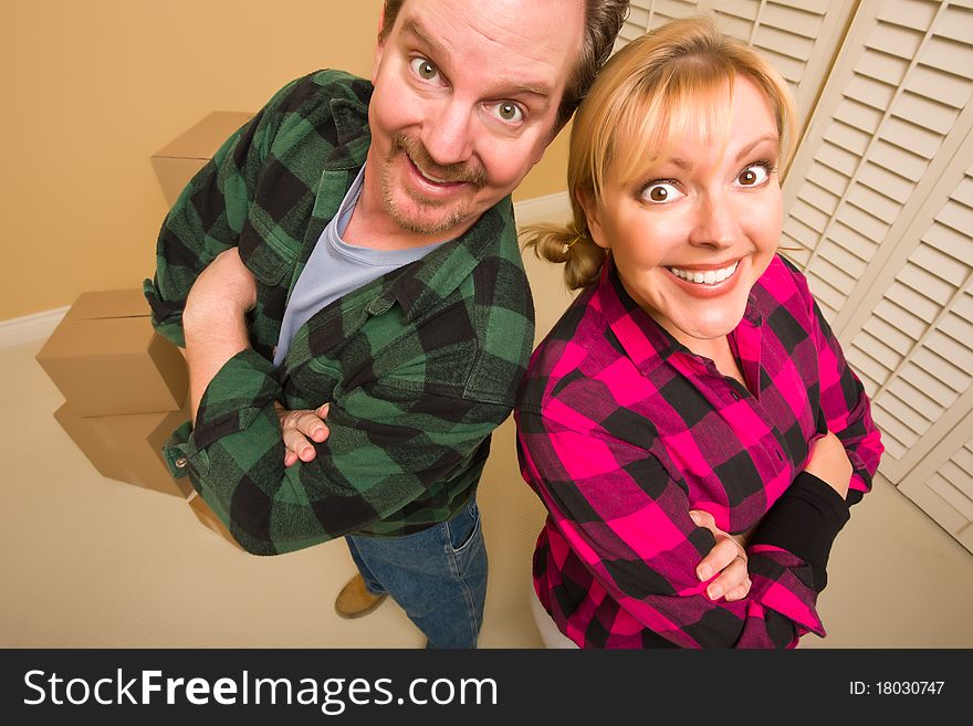 Proud Smiling Goofy Couple and Moving Boxes in Empty Room. Proud Smiling Goofy Couple and Moving Boxes in Empty Room.