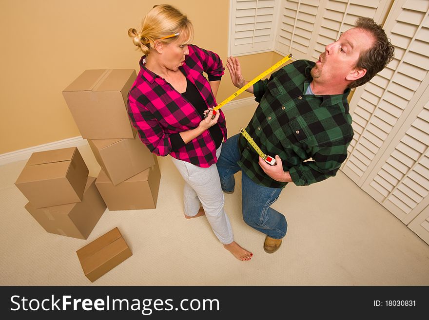 Couple Having Fun Sword Fight With Tape Measures