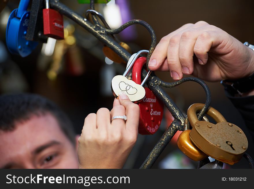 Lock lovers as a symbol of marital happiness in hands of the newlyweds