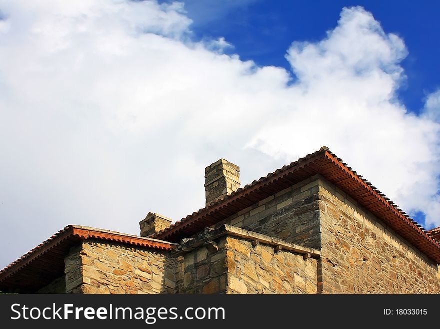 Old stone house against the blue sky with clouds in the medieval town