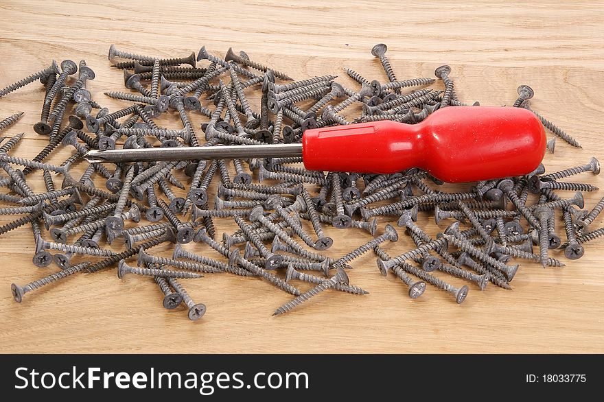 A pile of old screws and pliers closeup to the background of the tree