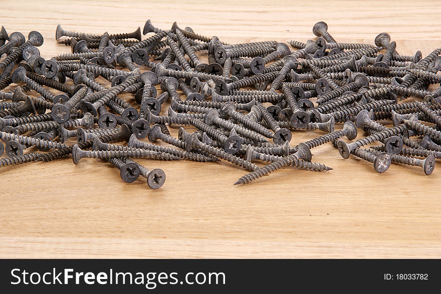 A pile of old screws closeup to the background of the tree