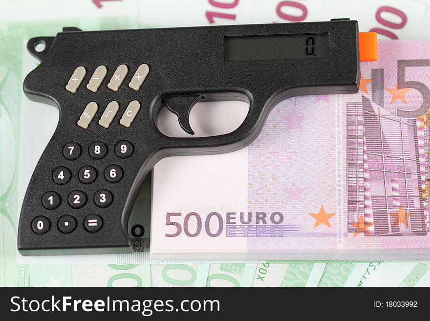 Calculator gun lies on the stack of banknotes Euro. Calculator gun lies on the stack of banknotes Euro