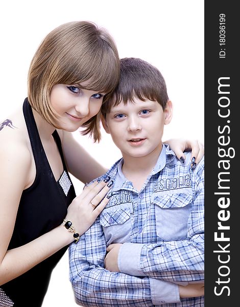 The sister with the brother stand having embraced on a white background. The sister with the brother stand having embraced on a white background