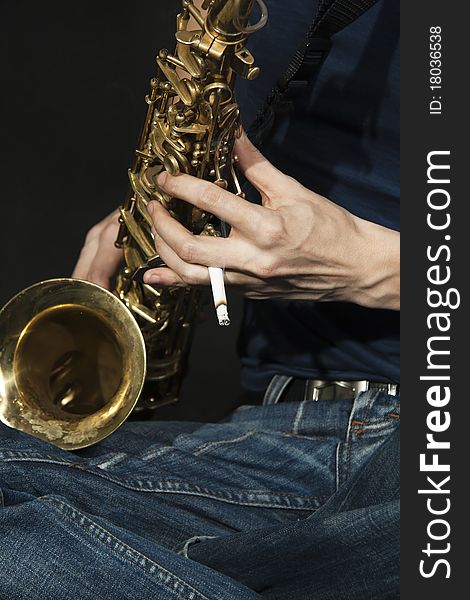 Close-up  cross-legged jazzman plays a saxophone