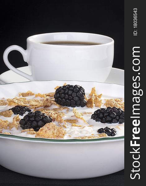 Light morning meal from cereals with berries of a blackberry and milk, in a coffee cup. Light morning meal from cereals with berries of a blackberry and milk, in a coffee cup.