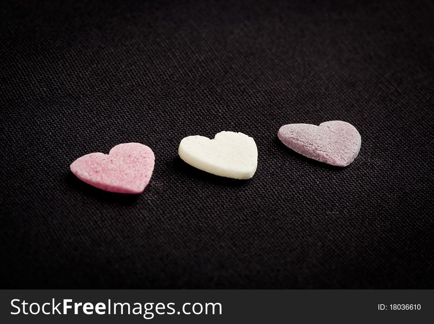 Heart shaped candy sweets on black bakground