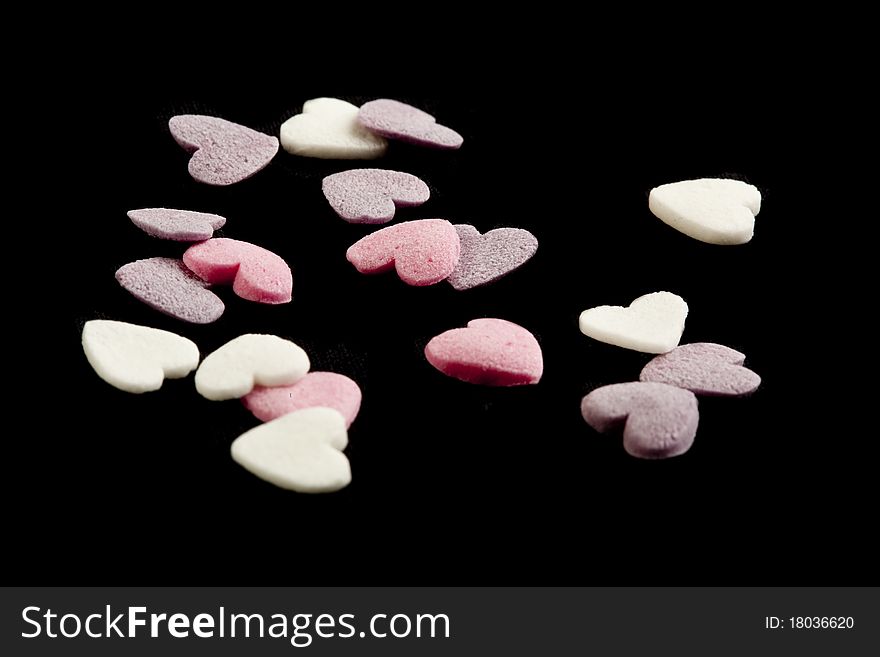 Heart shaped candy sweets on black bakground