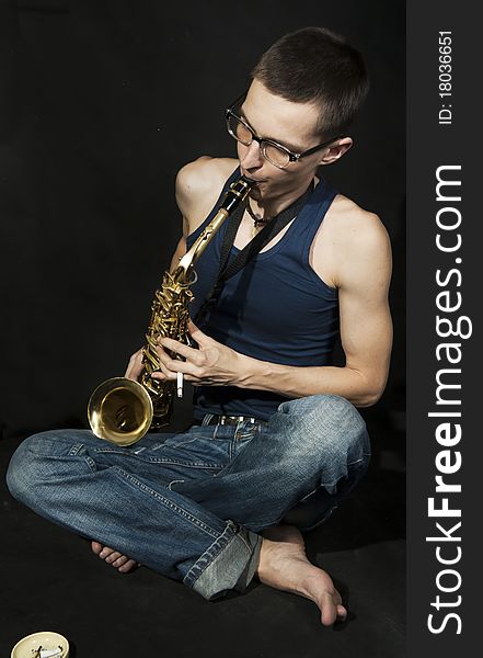 Cross-legged Jazzman Plays A Saxophone