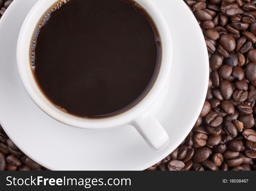 White cup with coffee on a grains background