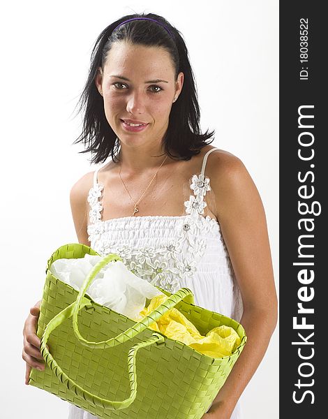 Young tanned healthy woman in a white summer cotton dress holding a green woven shopping bag. Young tanned healthy woman in a white summer cotton dress holding a green woven shopping bag