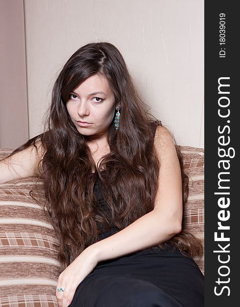 Charming young woman sitting  on a sofa