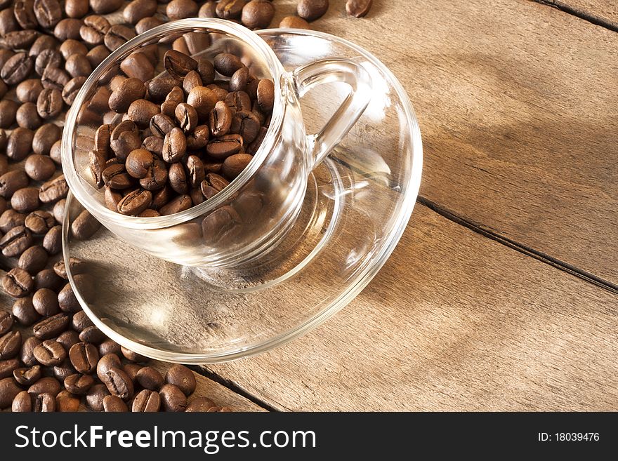 Coffee cup and grain and grains are scattered on the wooden surface