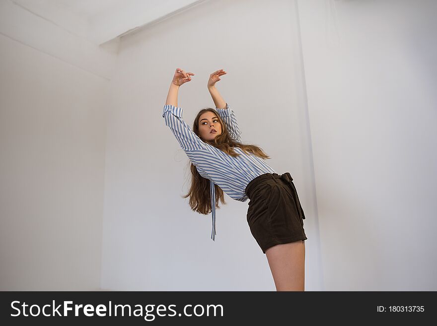 Young beautiful girl in a shirt and shorts is dancing in the style of contemp. Young beautiful girl in a shirt and shorts is dancing in the style of contemp.