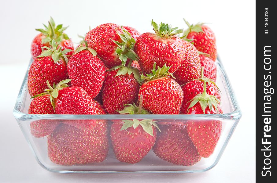 Strawberries in the glass bowl on white background