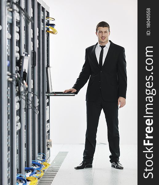 Young handsome business man it  engeneer in datacenter server room. Young handsome business man it  engeneer in datacenter server room