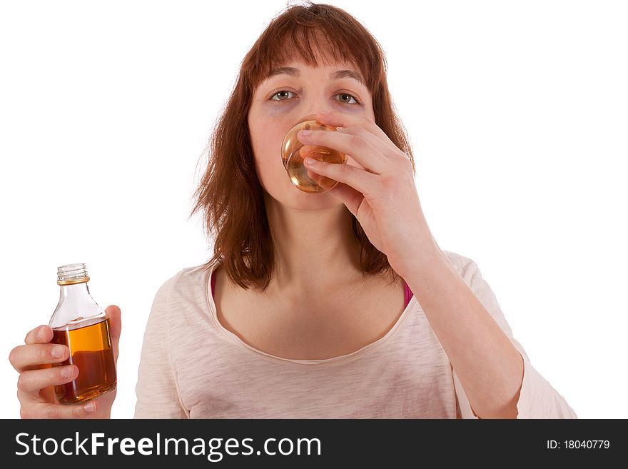 A young woman is drinking hard liquor and has a bottle in her hand. A young woman is drinking hard liquor and has a bottle in her hand