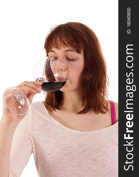 A Young woman is drinking red wine from a glass. A Young woman is drinking red wine from a glass