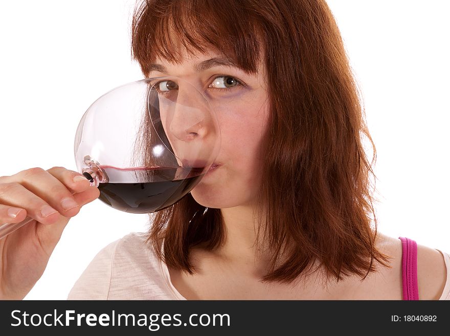 A Young woman is drinking red wine from a glass. A Young woman is drinking red wine from a glass