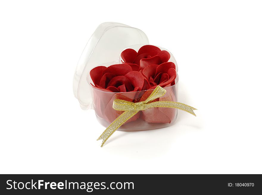 Buds of roses from a fabric in a transparent box are isolated on a white background