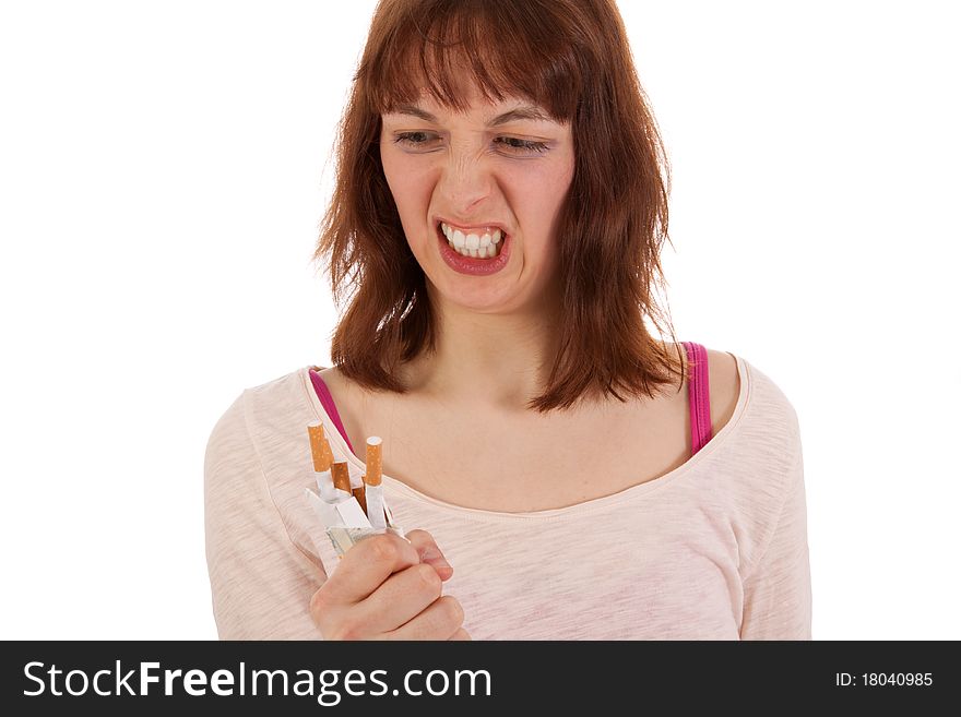 A young woman is angrily screwing up a pack of cigarettes. A young woman is angrily screwing up a pack of cigarettes