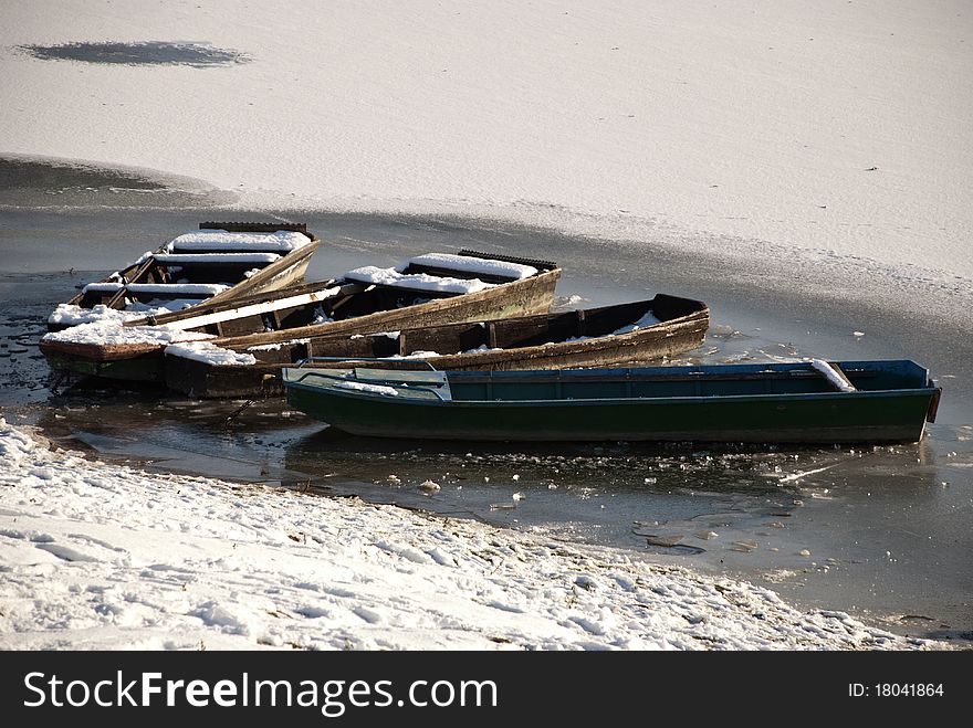 Three fishing boats moored on frozen water. Three fishing boats moored on frozen water.