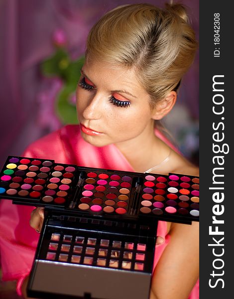 Beautiful girl holding a set of colored lipsticks for make-up. Beautiful girl holding a set of colored lipsticks for make-up