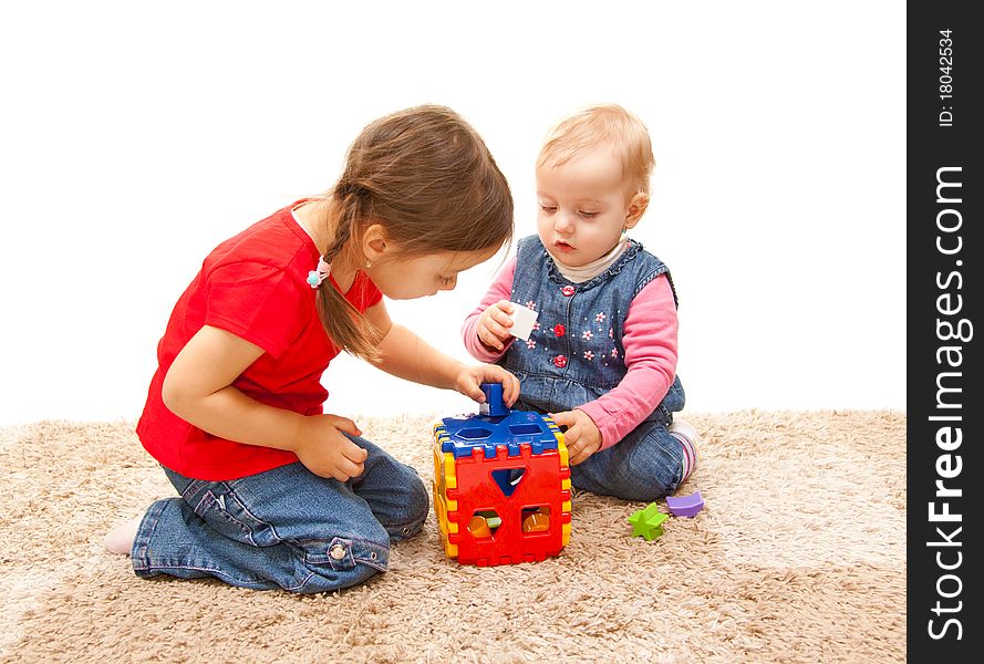 Sisters playing on the floor with cube toy. Sisters playing on the floor with cube toy