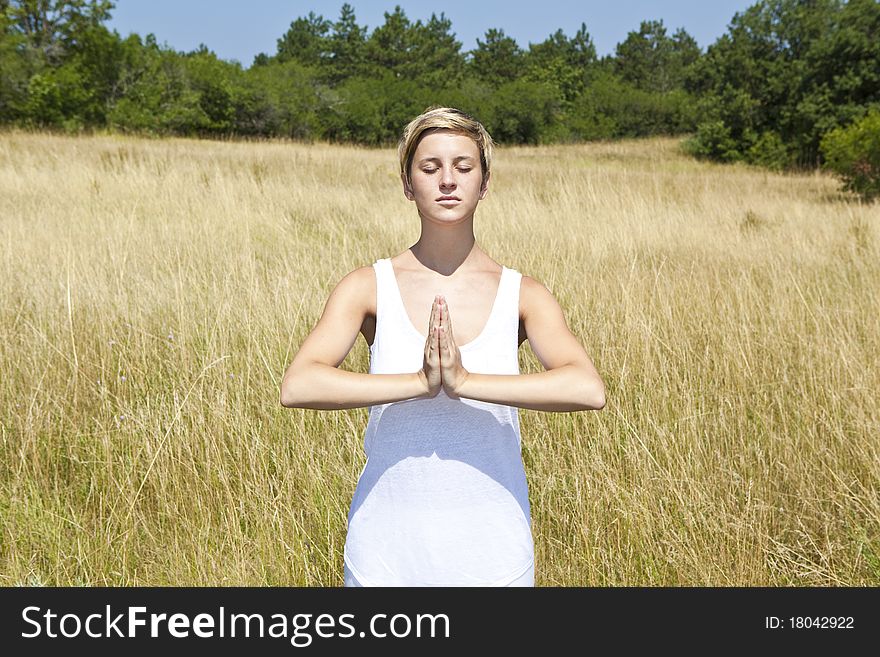 Young woman practicing yoga outdoor in summer