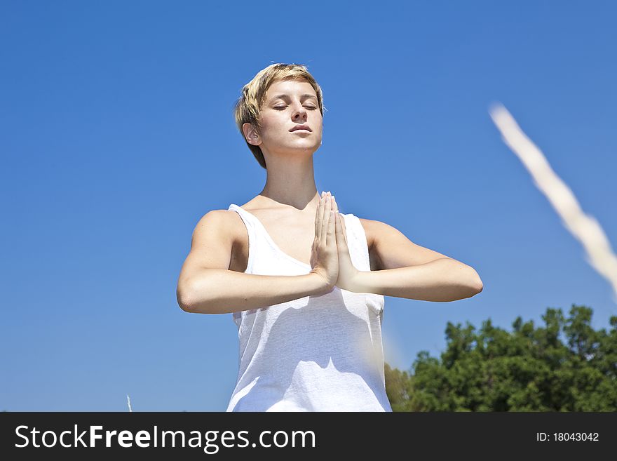 Young woman practicing yoga outdoor in summer