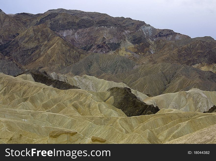 Medium view of eroded hilly landscape and jagged rocky hills with no vegitation in Death Valley, CA. Medium view of eroded hilly landscape and jagged rocky hills with no vegitation in Death Valley, CA