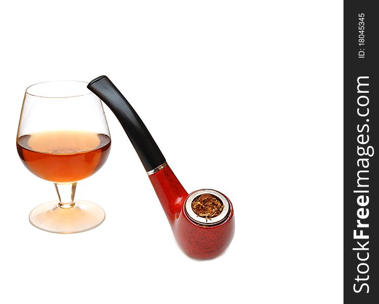 Pipe and glass of cognac on wood background. Pipe and glass of cognac on wood background