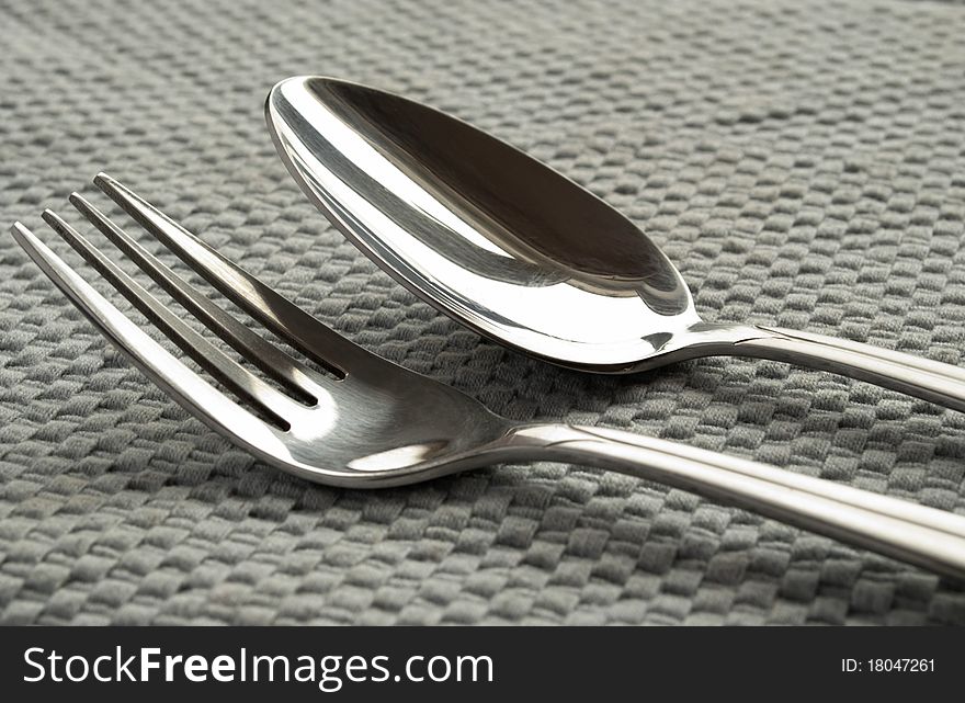 Fork and spoon on a gray napkin.