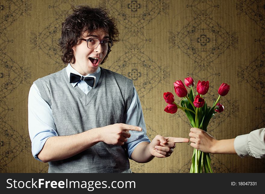 An image of a young man in big glasses and flowers. An image of a young man in big glasses and flowers