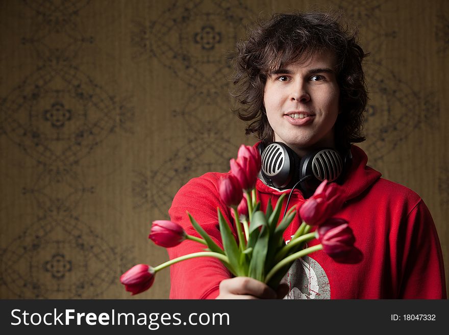 An image of a young man with red flowers. An image of a young man with red flowers