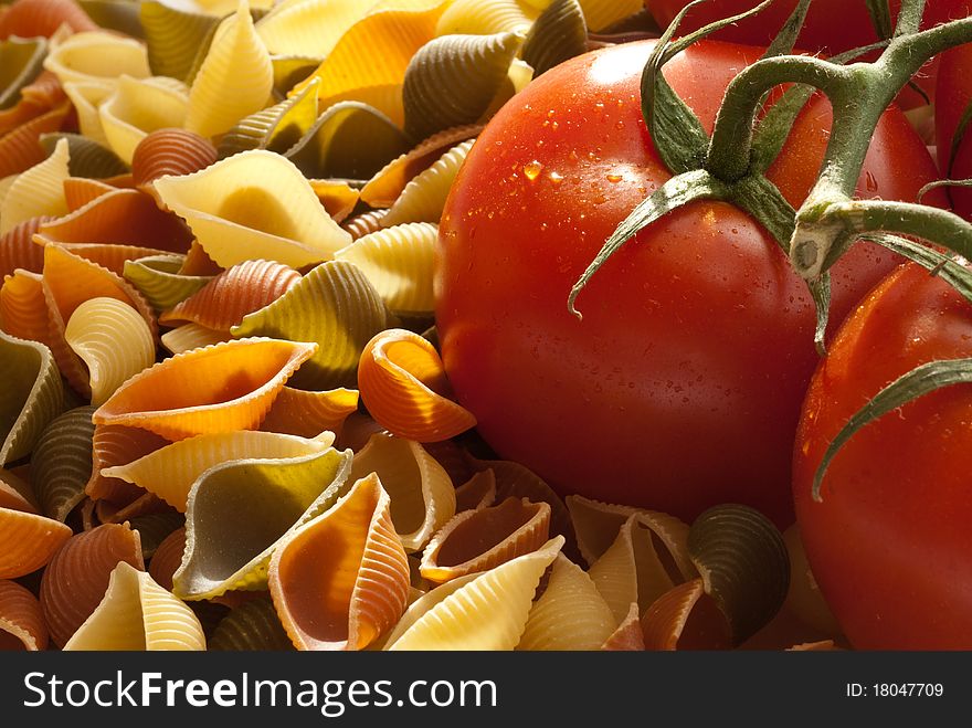 Fresh tomatoes and whole wheat pasta shells, shot in window light with room for ad copy. Fresh tomatoes and whole wheat pasta shells, shot in window light with room for ad copy