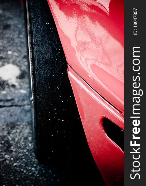 The tire and front end of a race car on concrete. The tire and front end of a race car on concrete