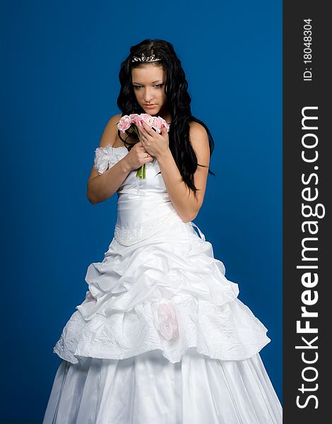 Portrait of beautiful happy bride in a wedding dress on blue background studio shot. Portrait of beautiful happy bride in a wedding dress on blue background studio shot